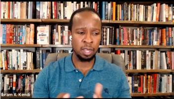 Dr. Ibram Kendi, a Black man in a blue shirt in front of a book shelf